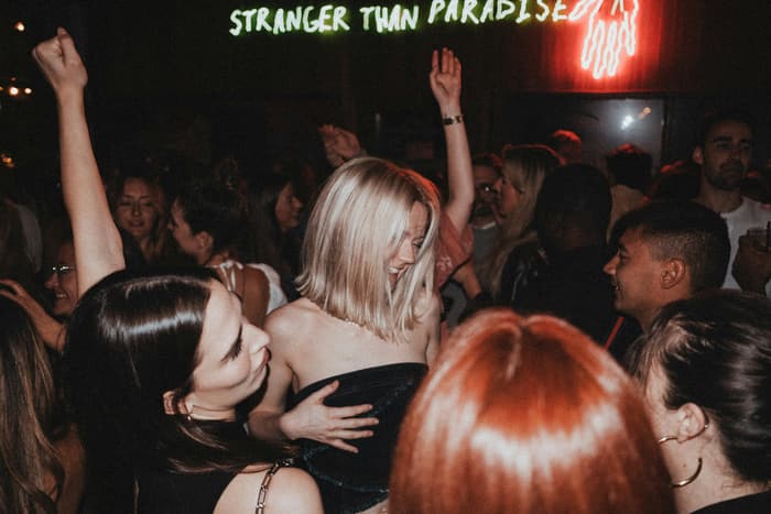 A packed bar with hands in the air