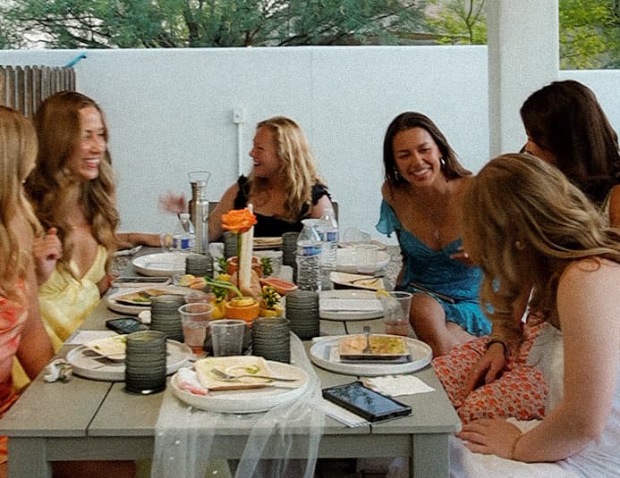 Friends laughing around a lunch table