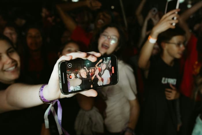 A guest holding up a selfie at a party