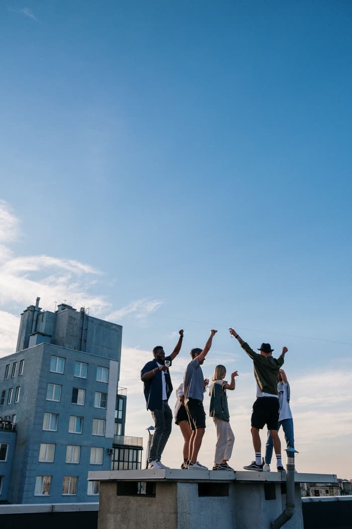 Friends cheering on a rooftop ledge