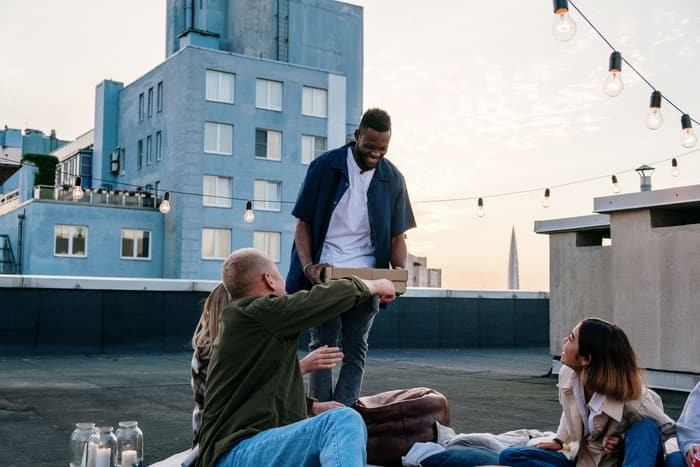 Guests talking on a rooftop under string lights